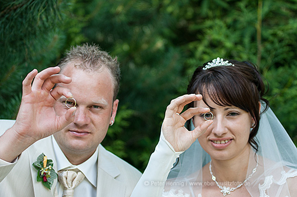 Foto Hochzeit Brautpaar schaut durch Trauringe